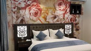 a bedroom with a large bed with a floral wallpaper at أزد للشقق المخدومة in Tanomah