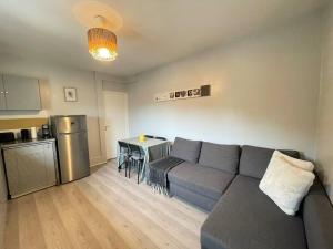 a living room with a couch and a kitchen at Résidence Tivoli, Trouville, 2min plage in Trouville-sur-Mer