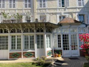a large building with aconservatory in front of it at Résidence Tivoli, Trouville, 2min plage in Trouville-sur-Mer +4 photos