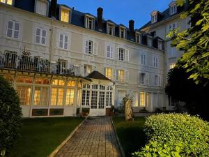 a large white building with its lights on at Résidence Tivoli, Trouville, 2min plage in Trouville-sur-Mer