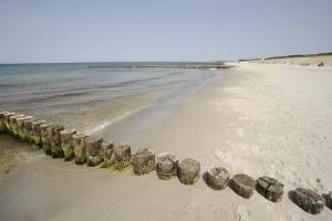 uma praia com uma fileira de pedras na areia em Susewind em Warnemünde