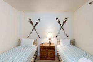 two beds in a room with crossed skis on the wall at Turtle Cove in Glenora