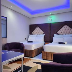 a hotel room with two beds and a table and chairs at Duplessis Lodge in Kempton Park