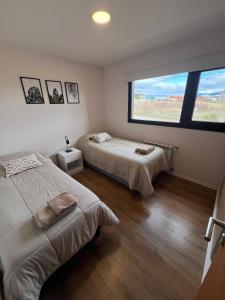 a bedroom with two beds and a large window at Casita Trevelin in Trevelin