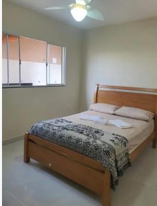 a bed in a bedroom with a ceiling fan at Casa das Americas in Nova Almeida