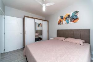 una camera da letto con un letto e un ventilatore a soffitto di Apto Pe na Areia, direcao Ilha-Balneario Camboriu. a Balneário Camboriú