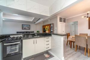 una cucina con piano cottura e una sala da pranzo di Apto Pe na Areia, direcao Ilha-Balneario Camboriu. a Balneário Camboriú