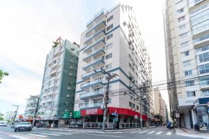 due edifici alti in una strada di città con una macchina di Apto Pe na Areia, direcao Ilha-Balneario Camboriu. a Balneário Camboriú