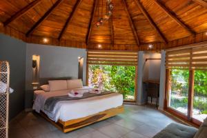 a bedroom with a large bed and large windows at Saguamby Mindo Lodge in Mindo