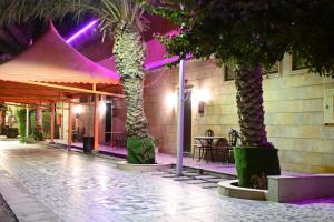 a building with two palm trees in front of it at شاطئ العرب الرايس in Rayyis