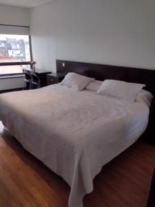 a bedroom with a large white bed with a window at Depto torre Bayres Obelisco in Buenos Aires