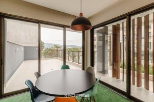 a table and chairs in a room with a balcony at YHD - Condomínio c/ piscina perto da UFSC in Florianópolis