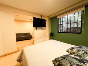 a bedroom with a bed and a flat screen tv at Nuevo estudio cerca de Plaza Mayor NID101 By Roots Rentals in Medellín