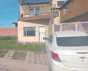 a white car parked in front of a house at Depto Ruta 3 in Trelew