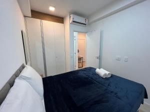 Un dormitorio con una cama con una manta azul. en Belíssimo Studio Nex one, próx metrô Vila Mariana, en São Paulo 15 fotos más