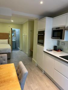 ロンドンにあるMarldon Olympia Hotelのキッチン、リビングルーム(ベッド1台、テーブル付)