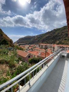 a balcony with a view of a city at Lovely newly refurbished, 1 bedroom top floor apartment with sea views, fast WI-FI CABLE TV and Netflix in Ribeira Brava