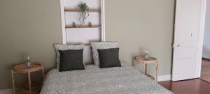 a room with two pillows on a bed with two tables at La villa Duchesse proche de Malo les Bains in Dunkerque