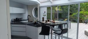 a kitchen with a counter and a table with chairs at La villa Duchesse proche de Malo les Bains in Dunkerque