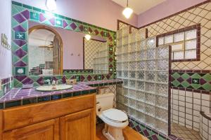 ein Badezimmer mit Toilette, Waschbecken und Spiegel in der Unterkunft Vistas de Las Olas West Suite in Puerto Peñasco