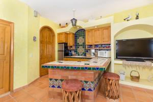 eine Küche mit einer Bar mit Hockern und einem TV in der Unterkunft Vistas de Las Olas West Suite in Puerto Peñasco + 5 Fotos