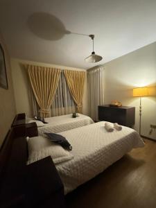 a bedroom with two white beds and a window at Casona tupuraya in Cochabamba +45 photos