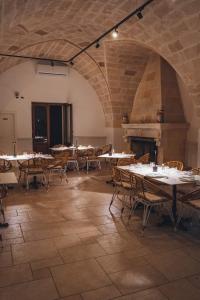 duży pokój ze stołami i krzesłami oraz kominkiem w obiekcie Borgo Angelica Hotel Ristorante Cocktail Bar w mieście Leporano Marina