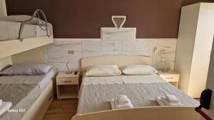 ein kleines Zimmer mit zwei Betten mit Handtüchern darauf in der Unterkunft B&B Aria e sole in Caulonia