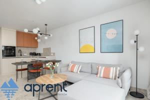 a living room with a couch and a kitchen at Apartament Sun&Moon PBA - Aprent in Pobierowo