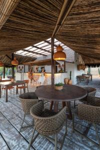 a patio with a table and chairs under a roof at Rumah Pousada in Barra Grande