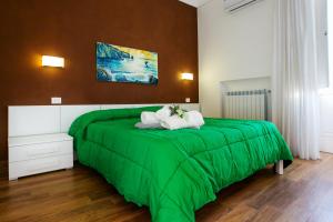 uma cama verde com duas toalhas brancas em Le Case Di Rosella em Vico Equense