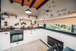 a kitchen with white cabinets and a window with birds on the wall at Wild nest Wolf Lux in Krajevi