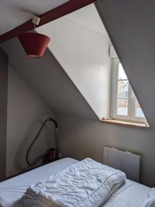 Zimmer im Dachgeschoss mit einem Bett und einem Fenster in der Unterkunft Appartement calme à 300 m de la plage-centre ville - Quiet appartment 300 m near city and beach in Mers-les-Bains