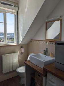 ein Badezimmer mit Waschbecken und Toilette und einem Fenster in der Unterkunft Appartement calme à 300 m de la plage-centre ville - Quiet appartment 300 m near city and beach in Mers-les-Bains