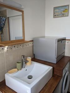 eine Küchenspüle mit einer Mikrowelle darüber in der Unterkunft Appartement calme à 300 m de la plage-centre ville - Quiet appartment 300 m near city and beach in Mers-les-Bains