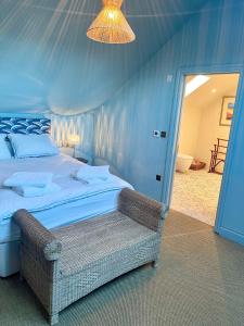 Dormitorio azul con cama y lámpara de araña en The Pool House, en Henley on Thames 32 fotos más