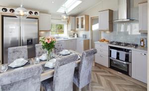a kitchen with a dining table with chairs and a kitchen with a stove at Sunrise Luxurious holiday home in Cubert +3 photos