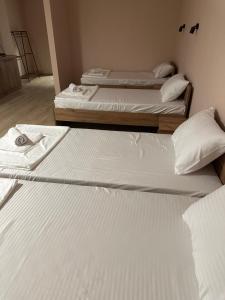 two beds in a room with white sheets at NIKA The architect DIAMOND OF GEVGELIA in Gevgelija