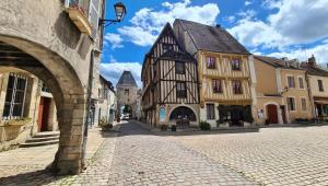 an empty street in a medieval town with buildings at Petite Maison centre du village in Noyers-sur-Serein