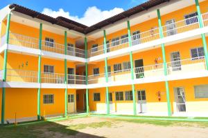 an orange building with white and green balconies at Condominio Oliveira in Maragogi