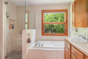 a bathroom with a tub and a sink and a window at Lakefront-hot Tub Gym Kayaks Paddleboards in Thompson +40 photos