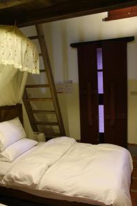 ein Schlafzimmer mit einem Etagenbett und einer Leiter in der Unterkunft Red Tomato B&B in Jinsha