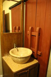 ein Bad mit einem Waschbecken und einem Spiegel in der Unterkunft Red Tomato B&B in Jinsha