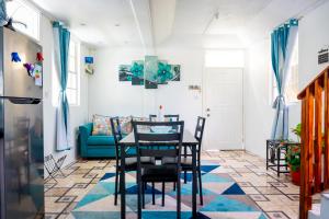 a dining room with a table and chairs and a blue couch at Rainbow Heights Apartment, Soufriere in Soufrière