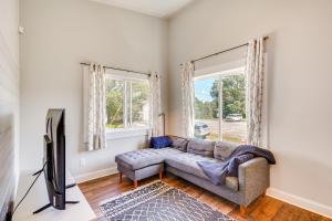 a living room with a couch and a tv at 3 Mi to Duke Downtown Durham Cottage! in Durham