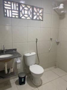 a bathroom with a toilet and a sink and a window at Porto Mirim House in Ceará-Mirim +11 photos