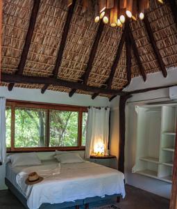 Un dormitorio con una cama con un sombrero encima. en Black Sand Hotel Boutique, en Zapotal