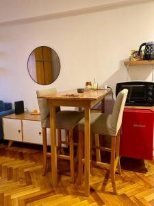 cocina con mesa de madera, sillas y espejo en Cozy apartment in the heart of San Telmo, en Buenos Aires