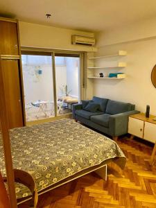 una sala de estar con una cama y un sofá en Cozy apartment in the heart of San Telmo, en Buenos Aires