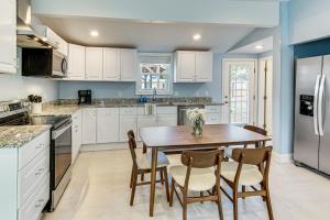 una cocina con armarios blancos y una mesa y sillas de madera. en Home with Private Yard - Walk to Swamp Rabbit Trail, en Greenville